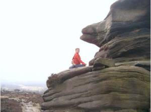 Jacqui in a sitting twist on a rock